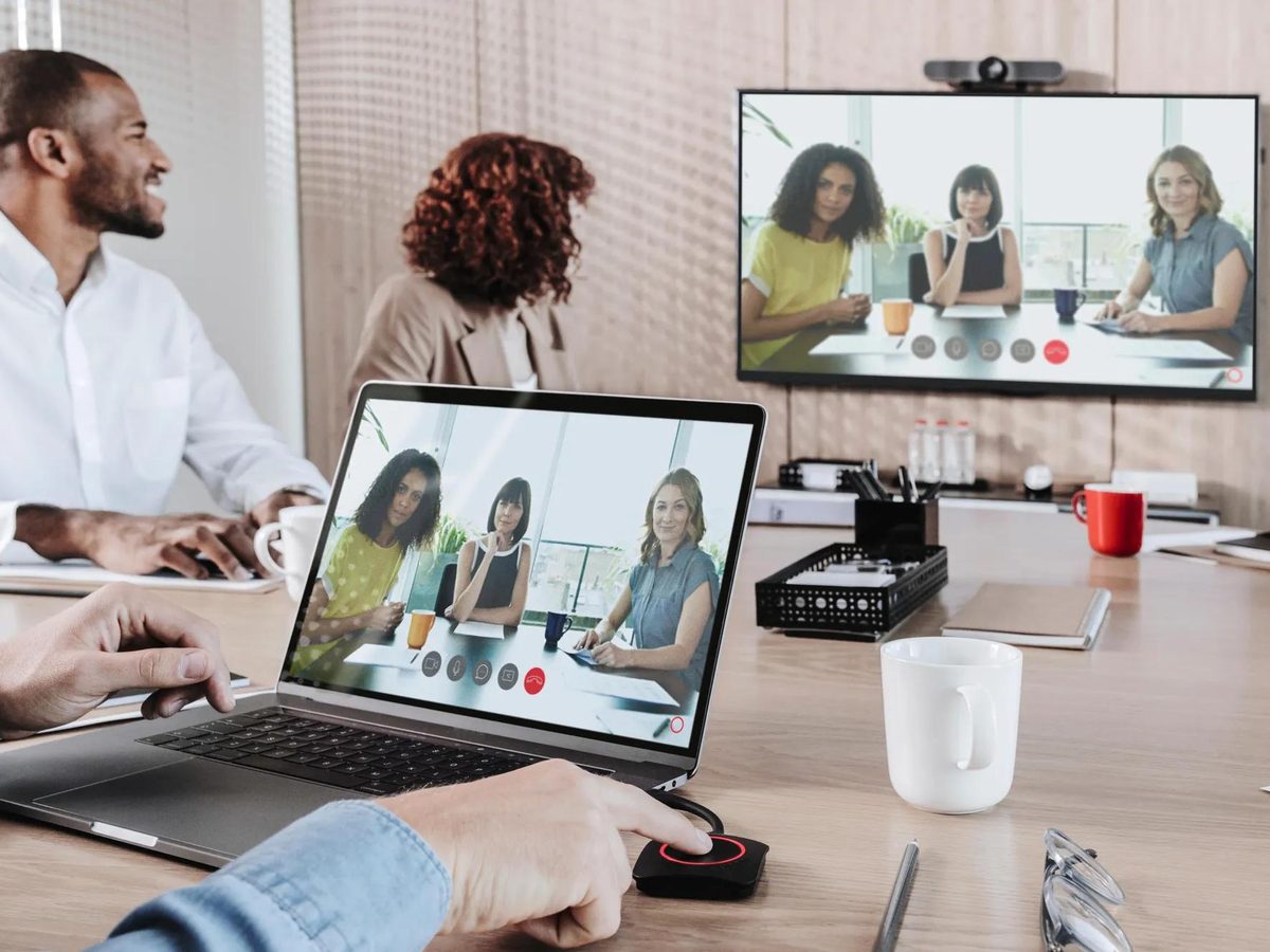 Hybride vergadering met ClickShare-knop op tafel